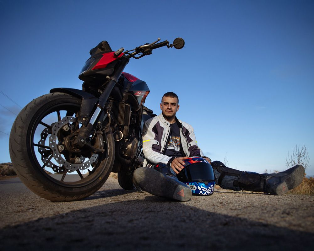 Ο Μιχάλης κάθεται στο δρόμο δίπλα στο Honda CB500 Hornet κρατώντας το κράνος Shoei NXR2 – Gas Rider Stories #5